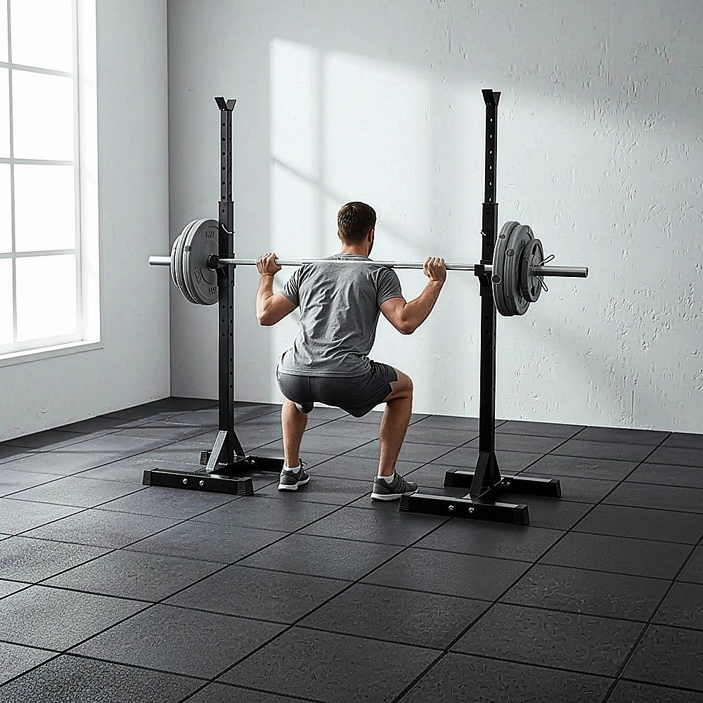 Man performing barbell squat with weight plates in gym setting