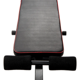 Adjustable weight bench seat with black padding and red trim for home gym workouts