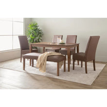 Modern dining room with brown upholstered chairs, wood table, bench, and indoor plant