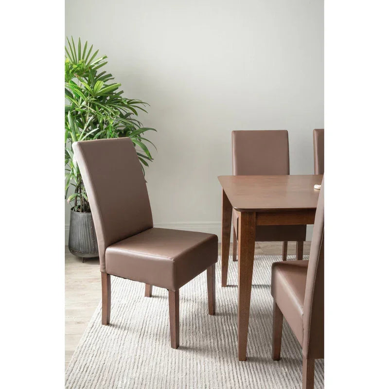 Brown faux leather dining chairs and wooden table in modern dining room with potted plant