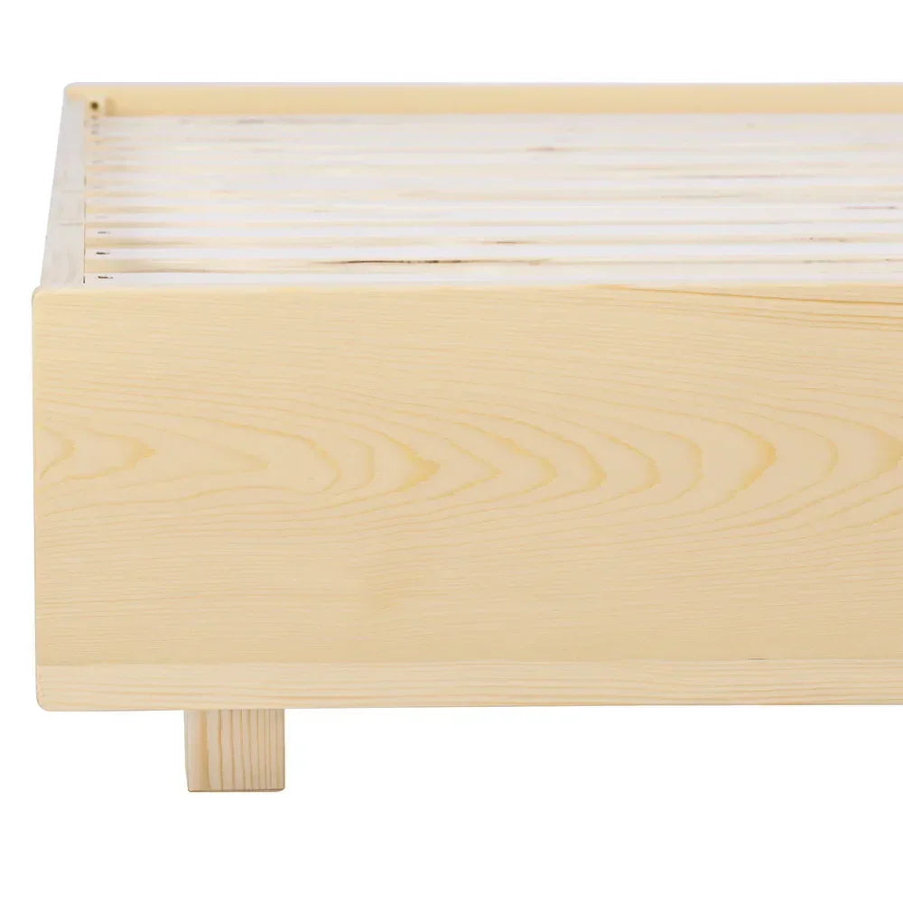 Close-up of a light natural wood bed frame with wooden slats and block legs