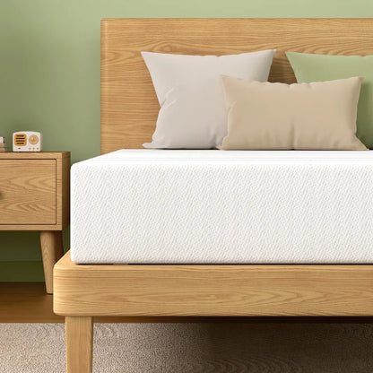 Modern bedroom with wooden bed frame, white mattress, neutral pillows, green wall, and wooden nightstand